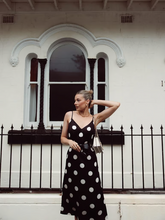 a lady wears a black and white polka dots printed midi dress